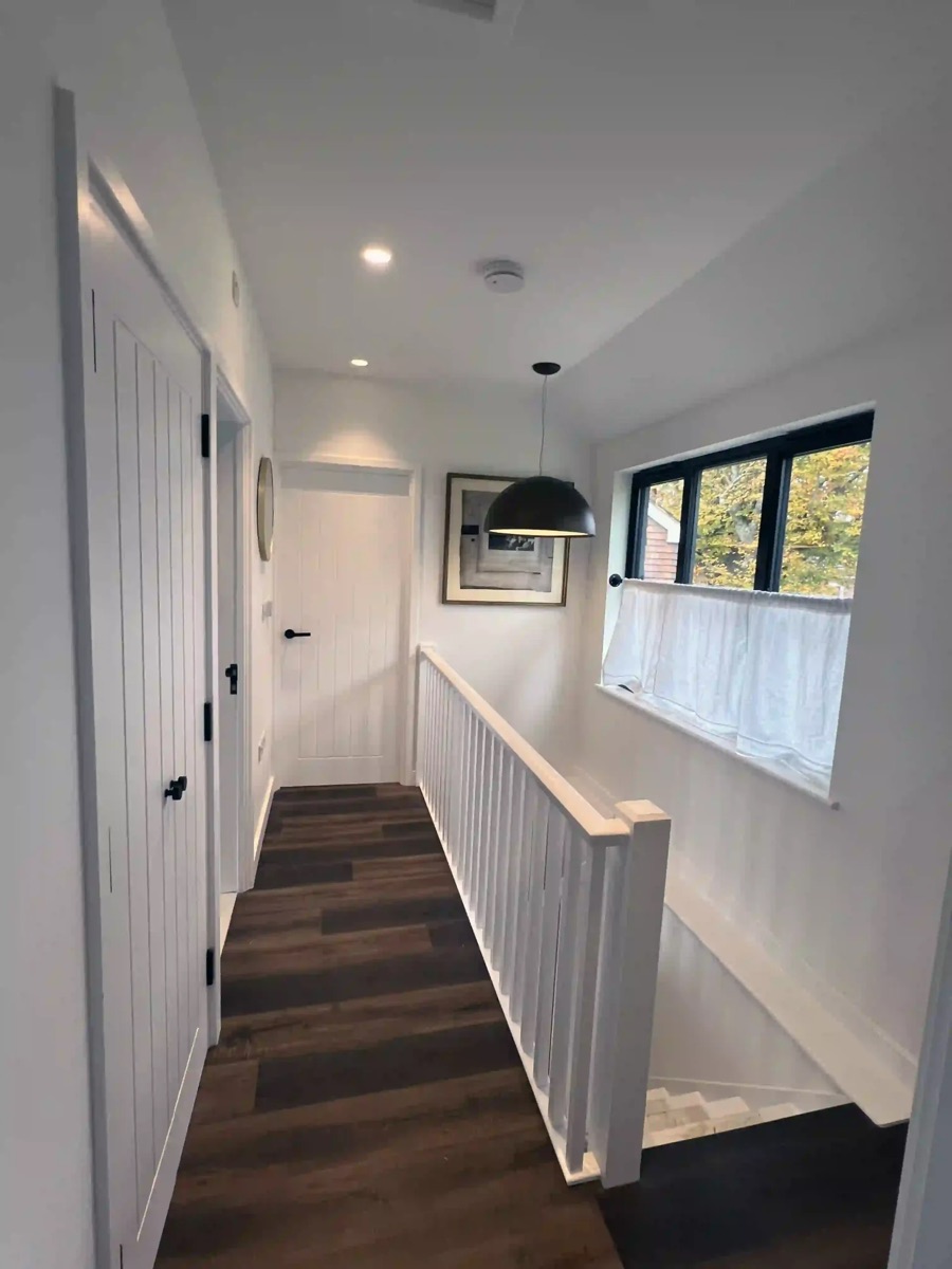 Landing with downlights and a black pendant light over the stairs