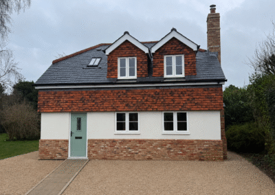 Newly built brick and render house with a gravel drive